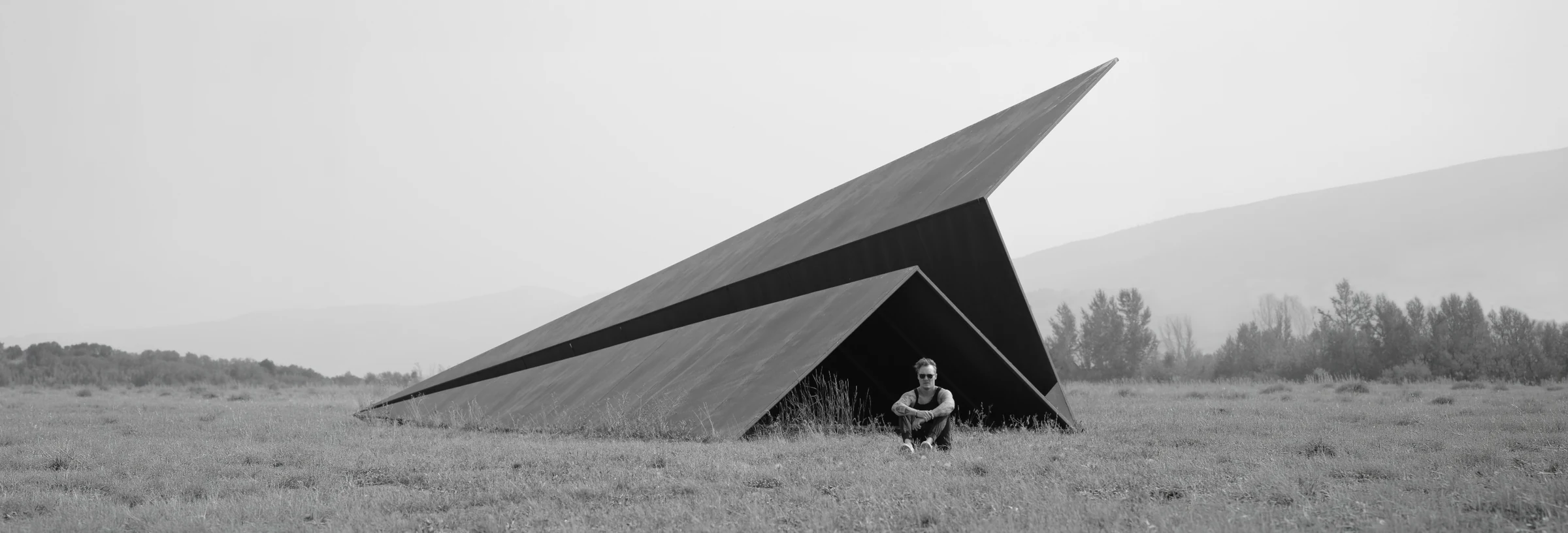 Griffin Loop seated beside the Launch Intention sculpture at Powder Mountain, Utah